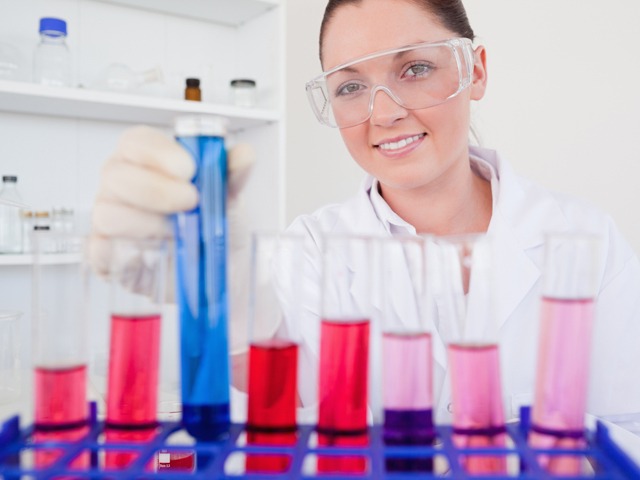 Beautiful red-haired female holding a test tube