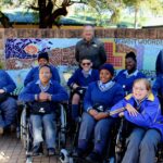 Meerhof School Principal, Kobus van der Merwe and some of the children who will use the wheelchairs Medipost Holdings recently donated to the school as part of its annual socioeconomic development initiatives.