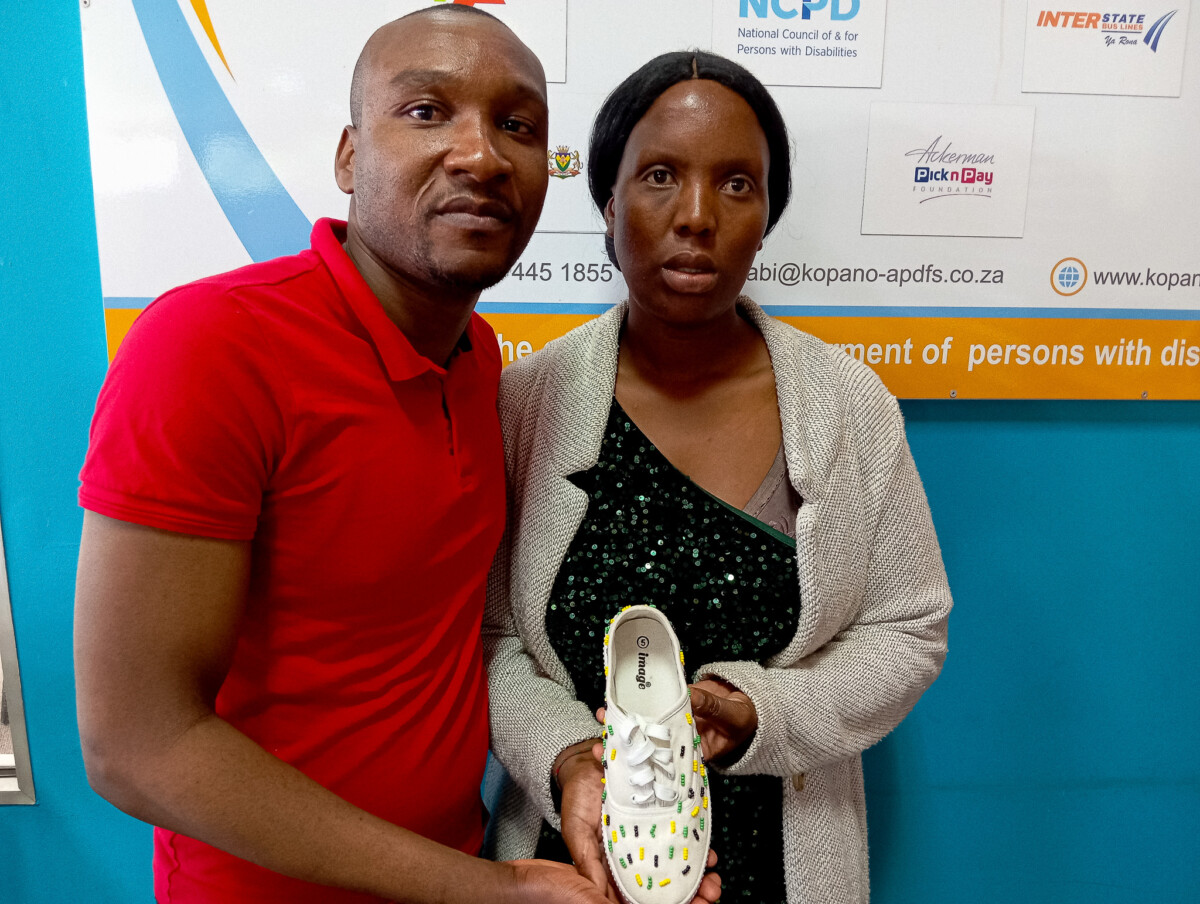 Dimakatso Molato from Kopano Workshop showcases her accessorised shoe. With her is NCPD's Communications Officer, Dylan Mashele.