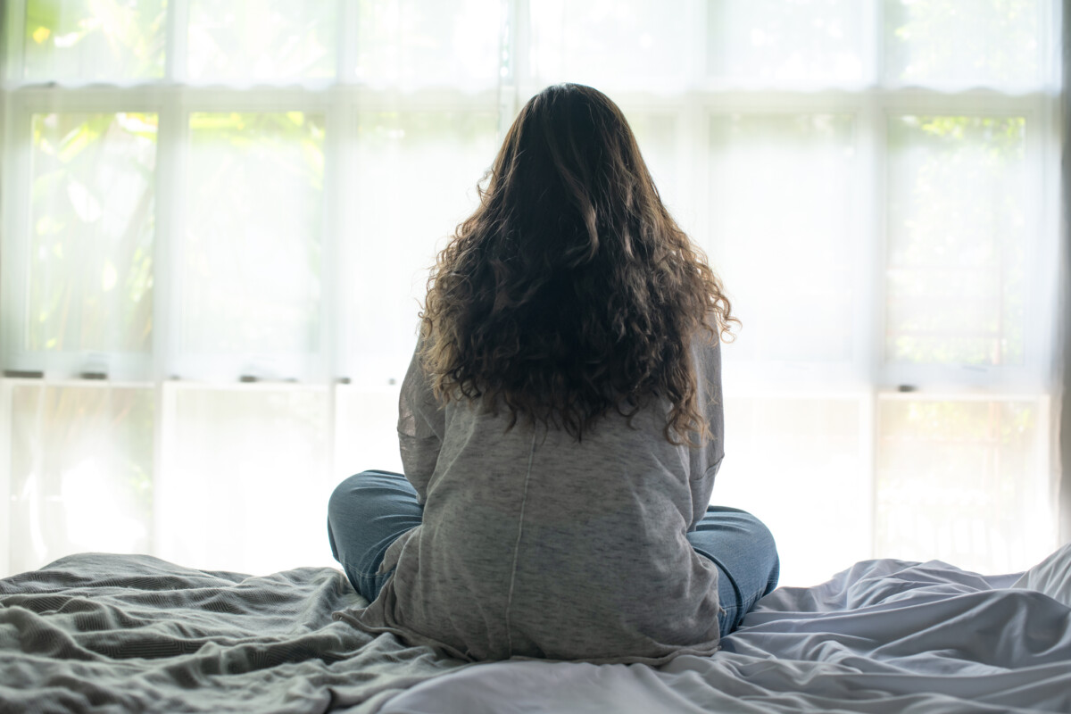 Young Asian woman sitting in a bedroom, feeling sad tired and worried suffering depression in mental health. in concept of depression anxiety and insomnia-Support for Schizophrenia is essential