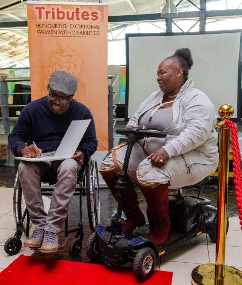 Musa E. Zulu signs a copy of his book for Nombuso Maphalala at the TRIBUTES Awards 2025